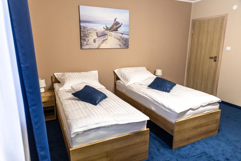 2 camas en una habitación con una foto en la pared en RR pokoje, en Kielce
