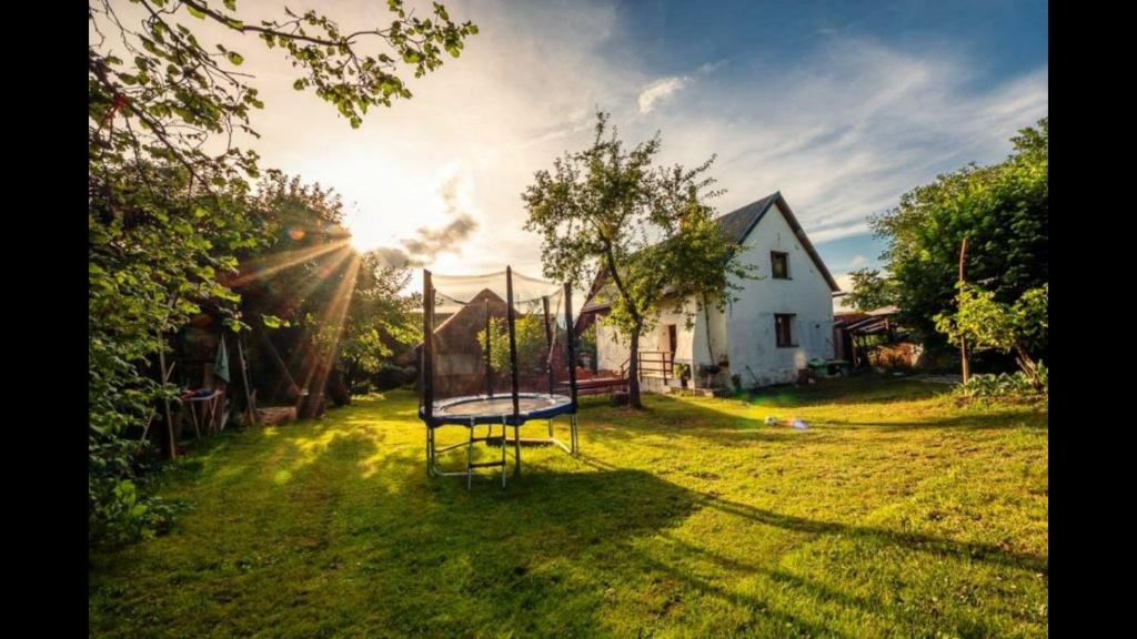 a swing set in a yard with a house at Liptovský Trnovec 178 in Liptovský Trnovec