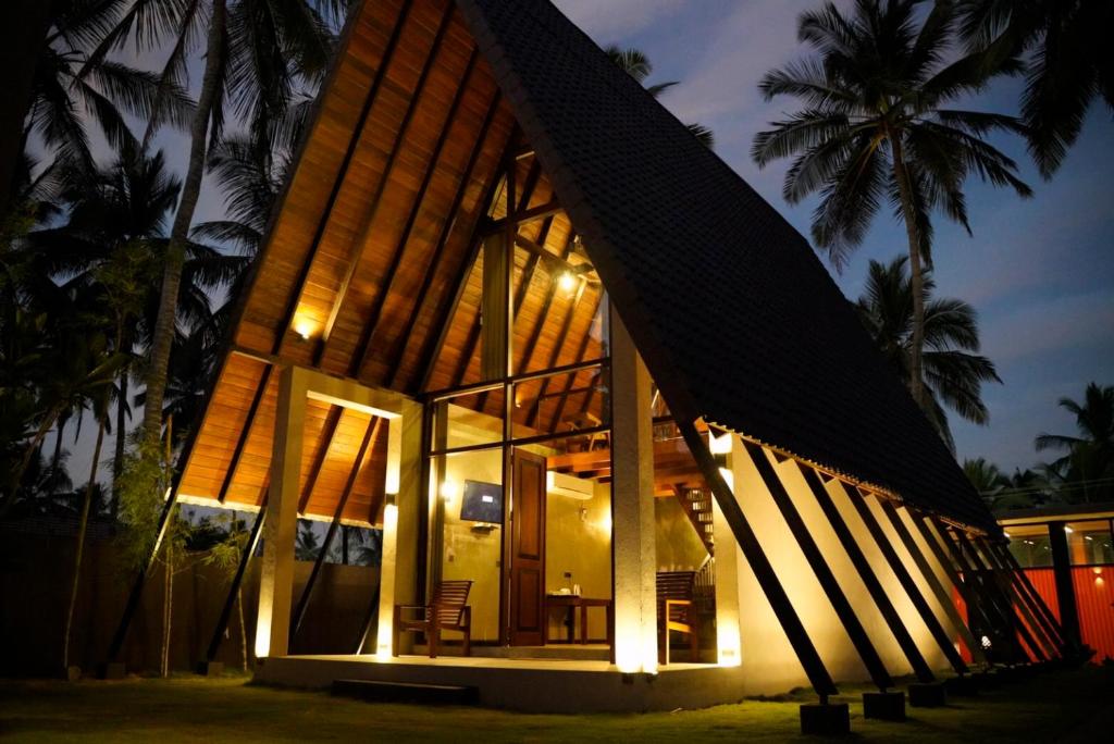 uma casa com um telhado de gambrel à noite em SOLUNA BEACH RESORT em Marawila