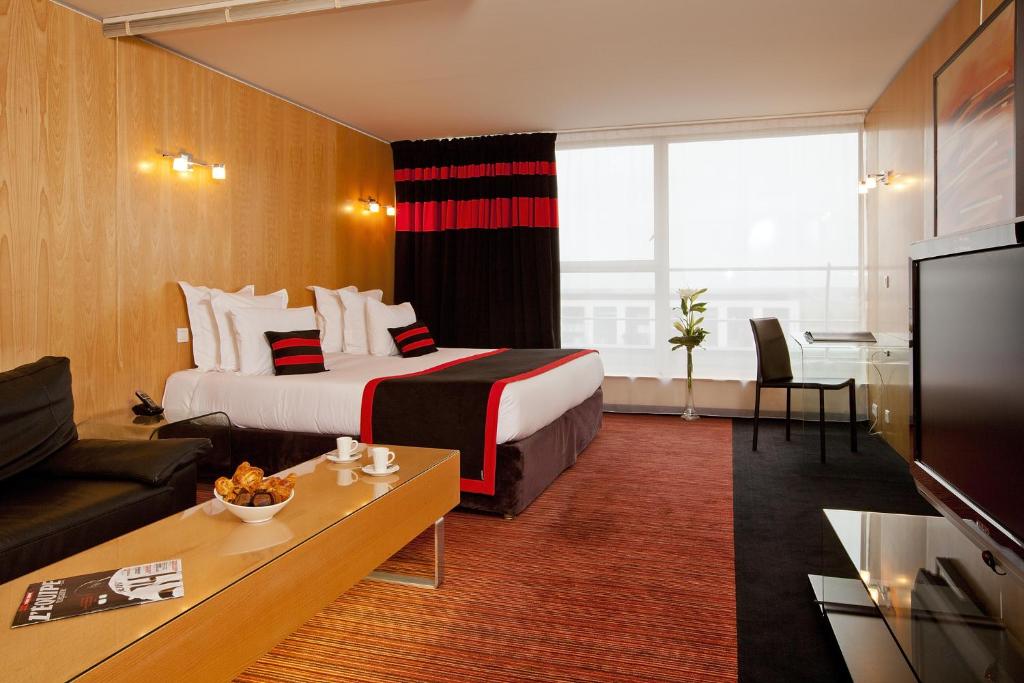 une chambre d'hôtel avec un lit et un canapé dans l'établissement Residhome Suites Paris Sénart, à Lieusaint
