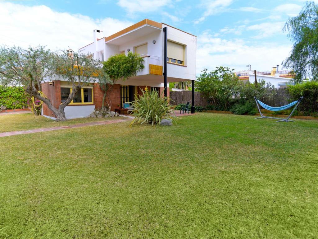 una casa con un patio con una hamaca azul en Holiday Home Francia by Interhome, en Sitges