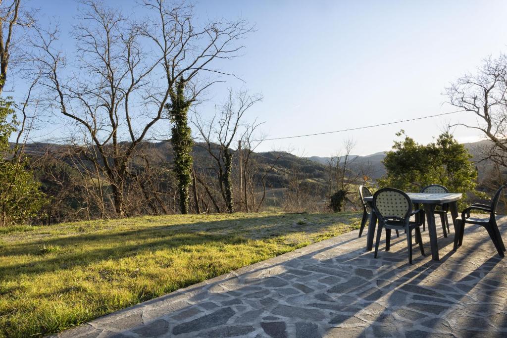 une table et des chaises sur une passerelle en briques avec un champ dans l'établissement Villa Viktoria & Andras, à Tredozio