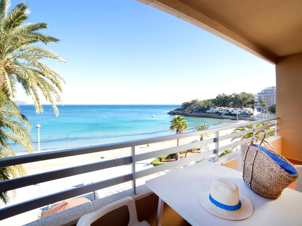 stół z kapeluszem i widokiem na plażę w obiekcie Apartment Voramar-5 by Interhome w mieście Calpe