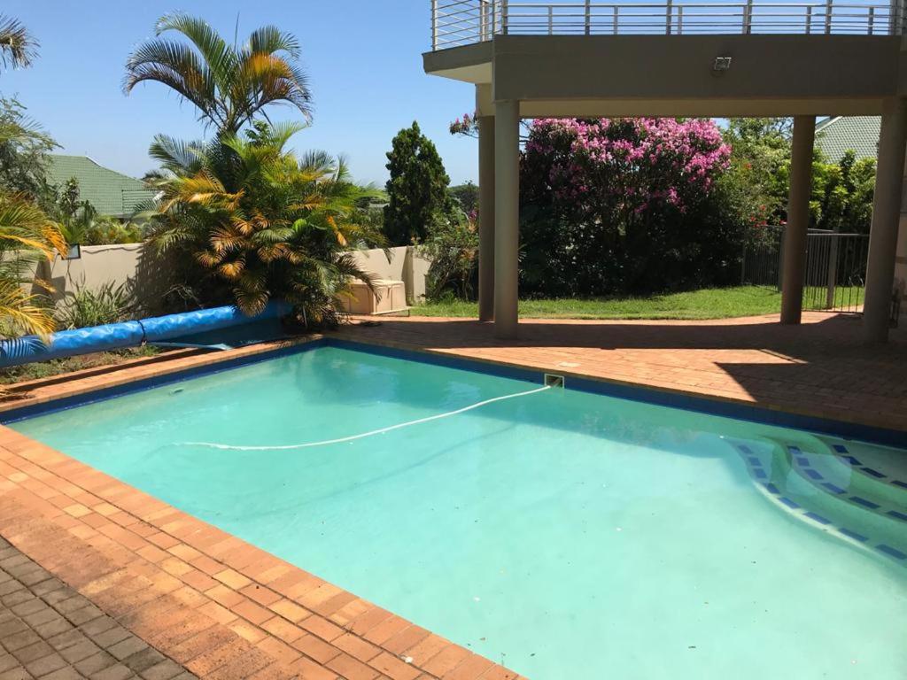 una piscina in un cortile con una casa di Somerset In a Durban
