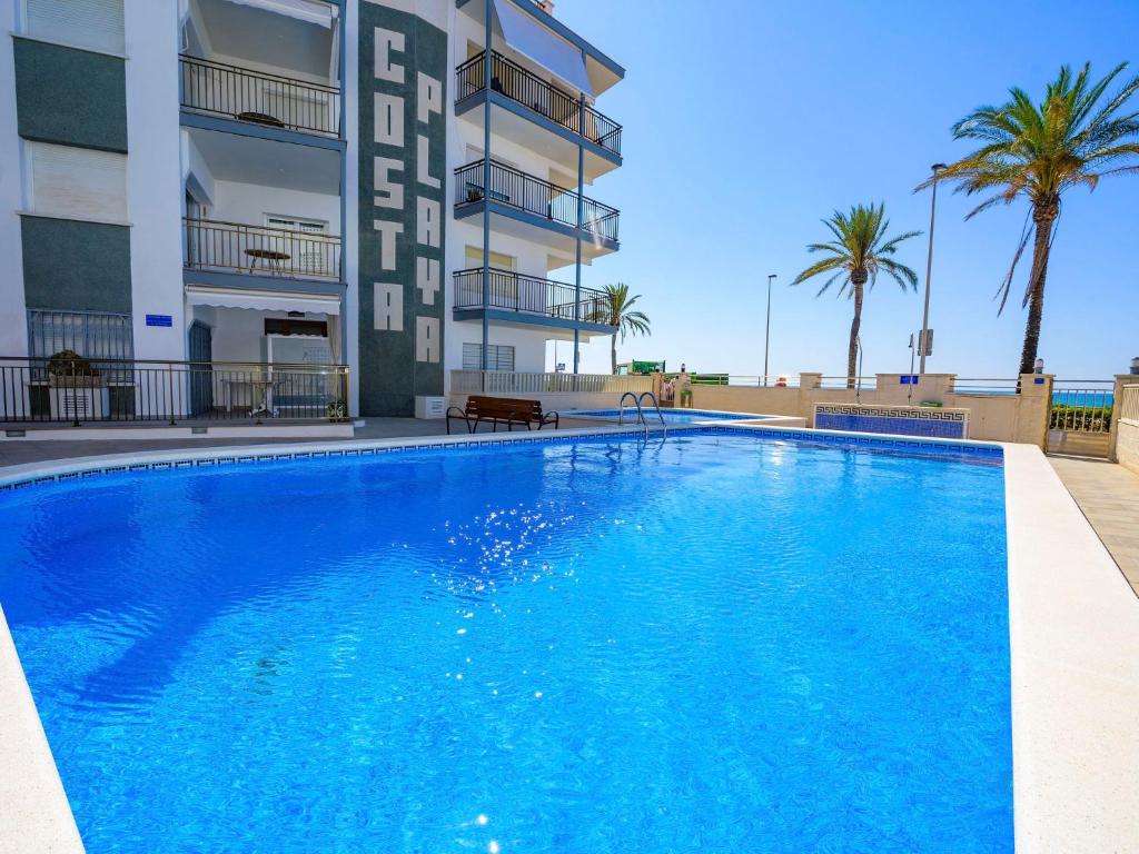una gran piscina azul frente a un edificio en Apartment Costa Playa by Interhome, en Cunit
