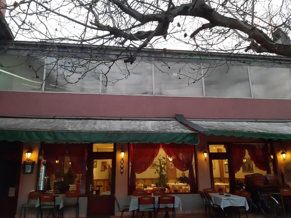 a restaurant with tables and chairs in front of a building at Šumatovac in Aleksinac