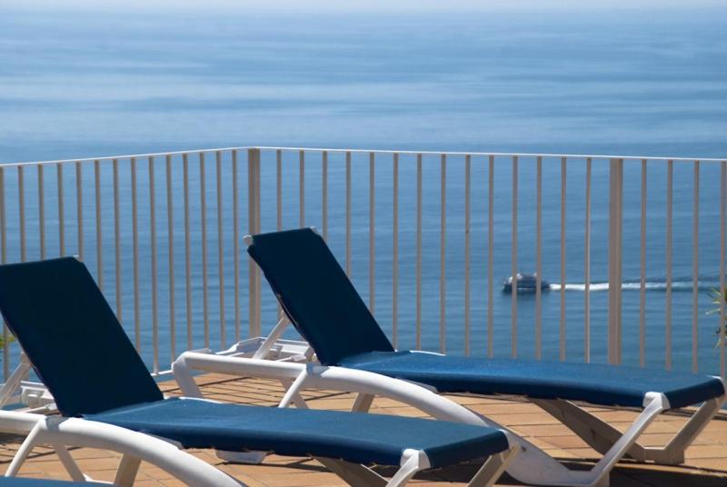 two blue and white chairs sitting on a deck overlooking the ocean at Club Villamar - Claire in Tossa de Mar