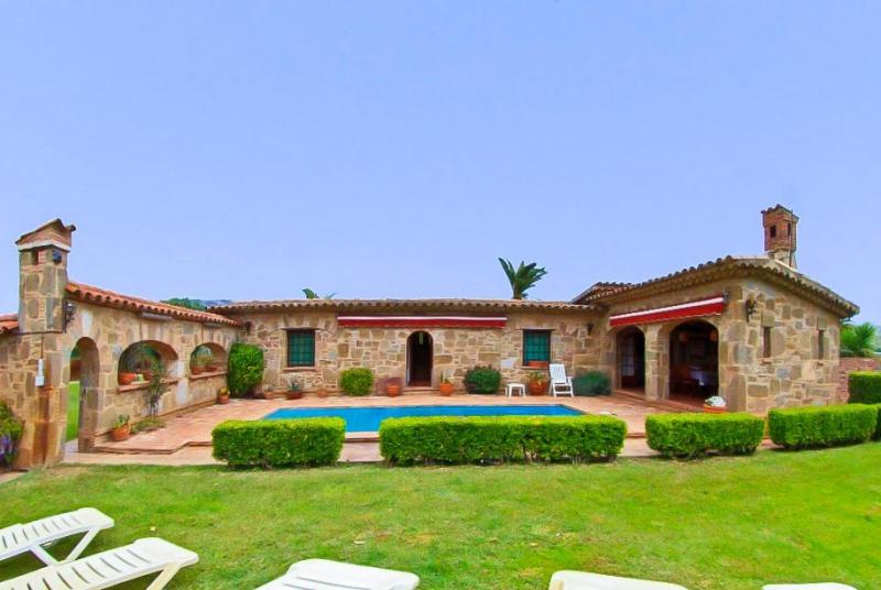 ein Steinhaus mit einem Pool im Hof in der Unterkunft Club Villamar - Descanso in Platja  d'Aro