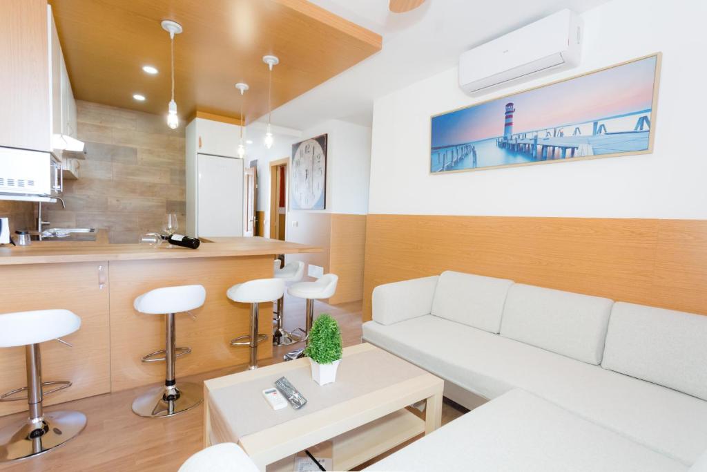 a living room with a white couch and a table at Flamingo Friendly Holiday Home in Playa del Ingles