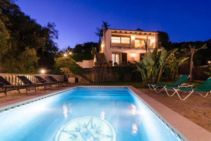 a swimming pool in front of a house at night at Club Villamar - Jamira in Tossa de Mar