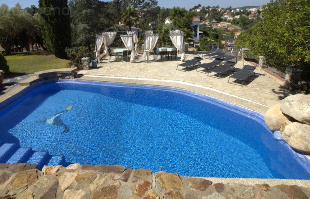una gran piscina azul con tumbonas alrededor en Club Villamar - La Cancha, en Lloret de Mar