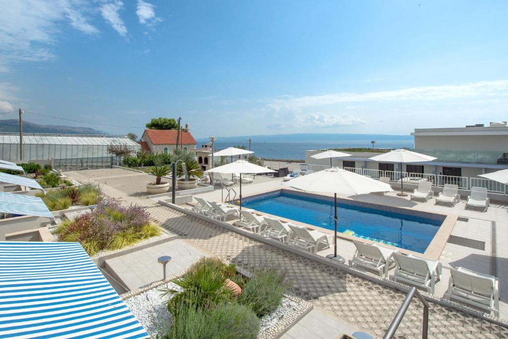 a swimming pool with chairs and umbrellas and the ocean at AS'S in Split