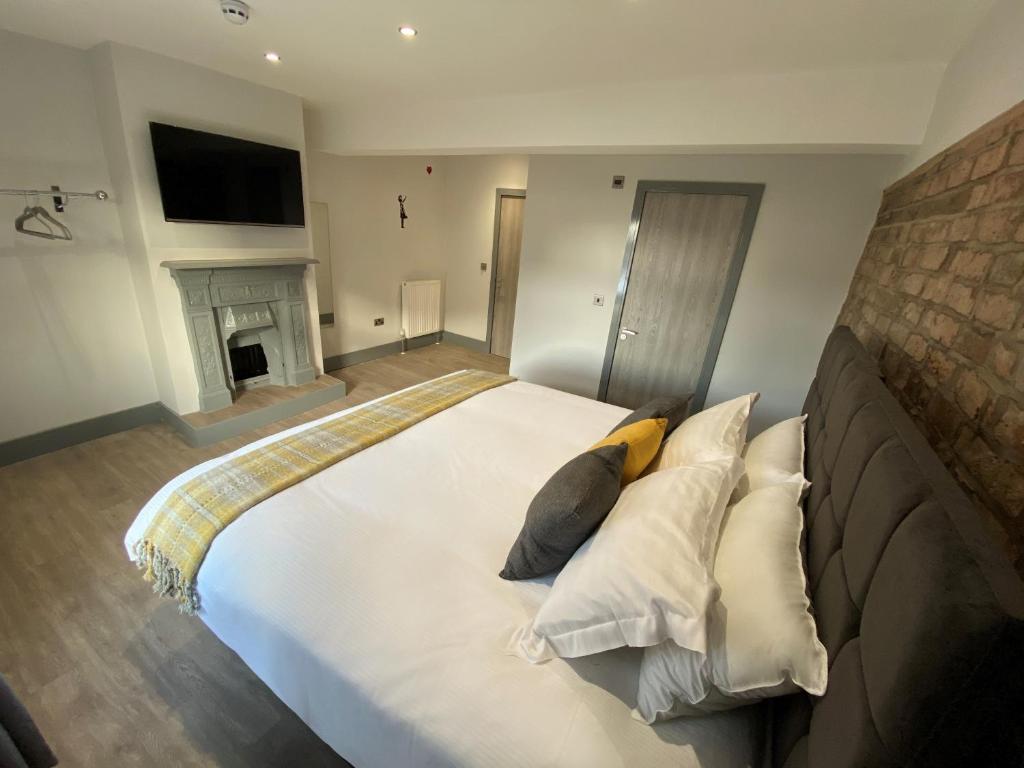 a bedroom with a large white bed with a fireplace at 6Adelphi in Preston