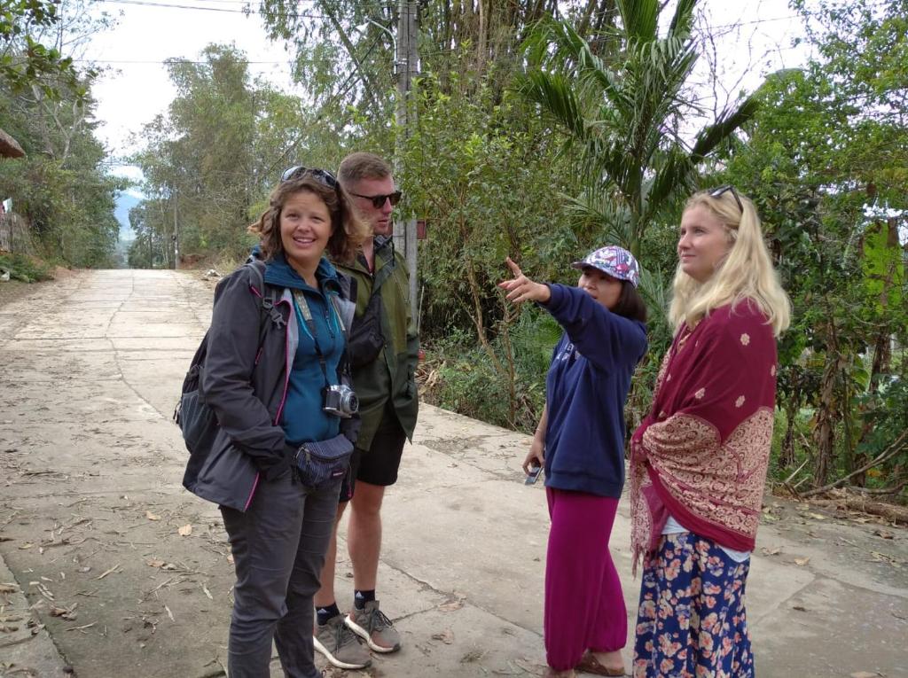 a group of people standing on a dirt road at Be's Home & Tours in Ha Giang