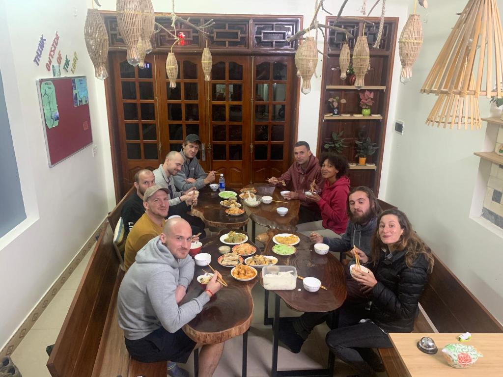 a group of people sitting at a table eating food at Be's Home & Tours in Ha Giang