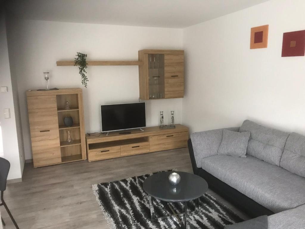 ein Wohnzimmer mit einem Sofa und einem Flachbild-TV in der Unterkunft Ferienwohnung Wildes Wässerchen in Bad Hersfeld