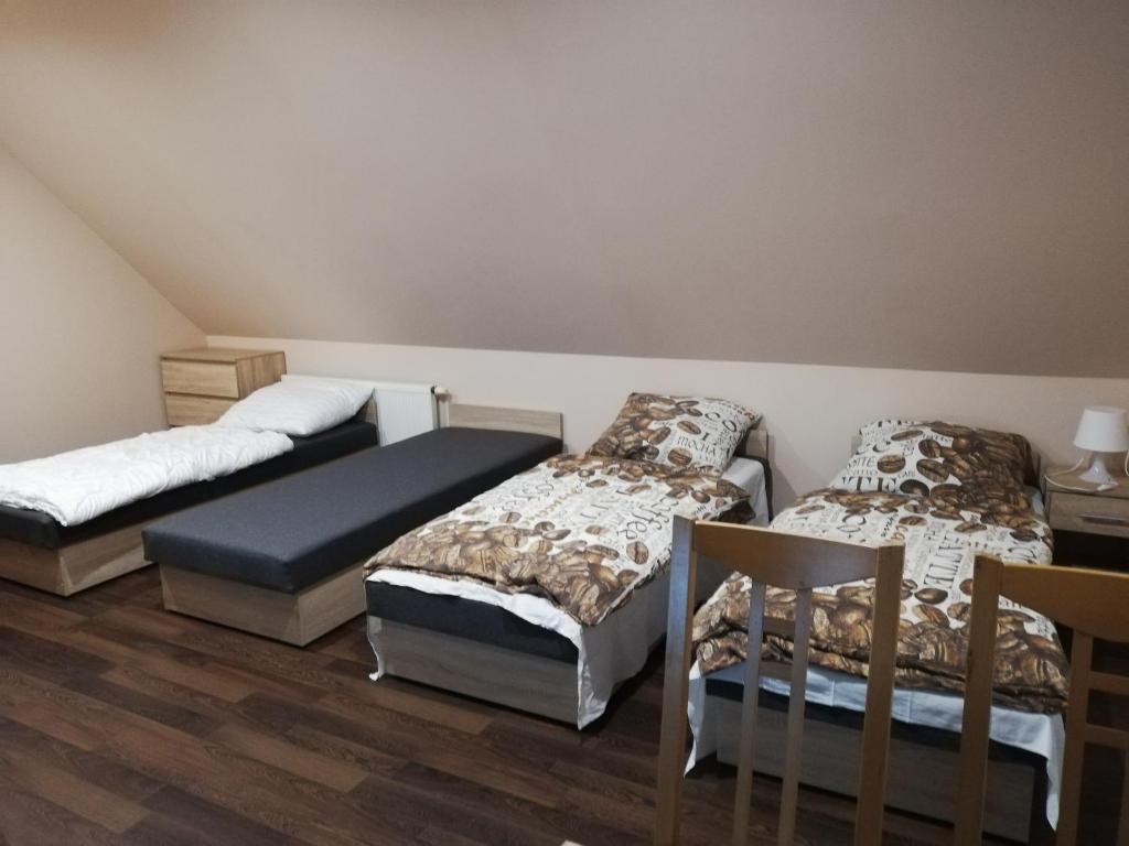 クドヴァ・ズドゥルイにあるPokoje gościnne Alicjaのベッド3台とテーブルが備わる部屋