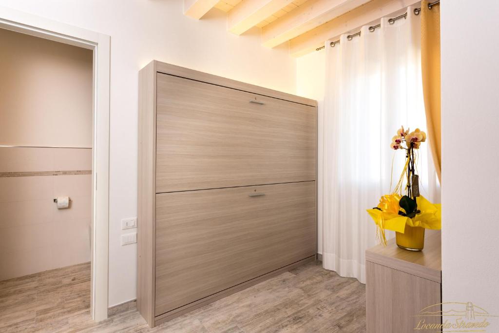 a closet with a large wooden door in a room at Locanda Stravedo in Pellestrina