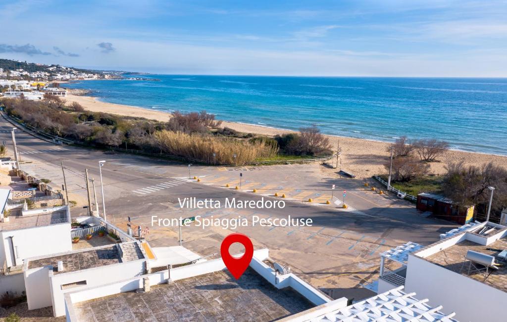uma vista para uma praia com um marcador vermelho em Villetta Maredoro - Fronte Spiaggia Pescoluse em Marina di Pescoluse