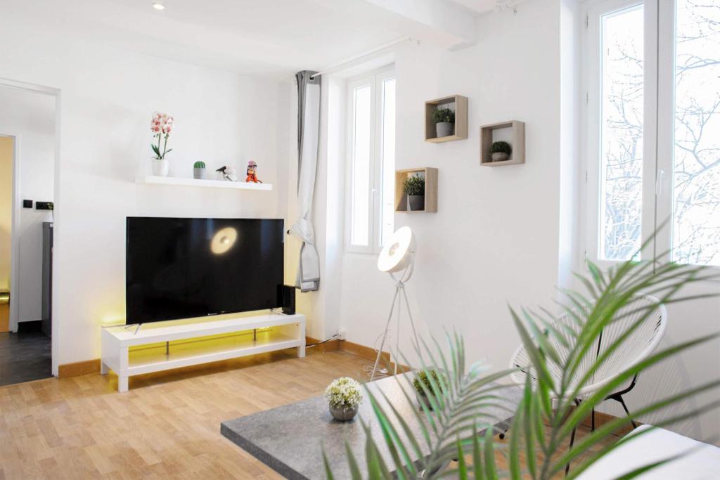 un salon avec une télévision à écran plat sur un mur blanc dans l'établissement GregBnb-com - T2 Design - CLIMATISÉ - WiFi Fibre, à Toulon