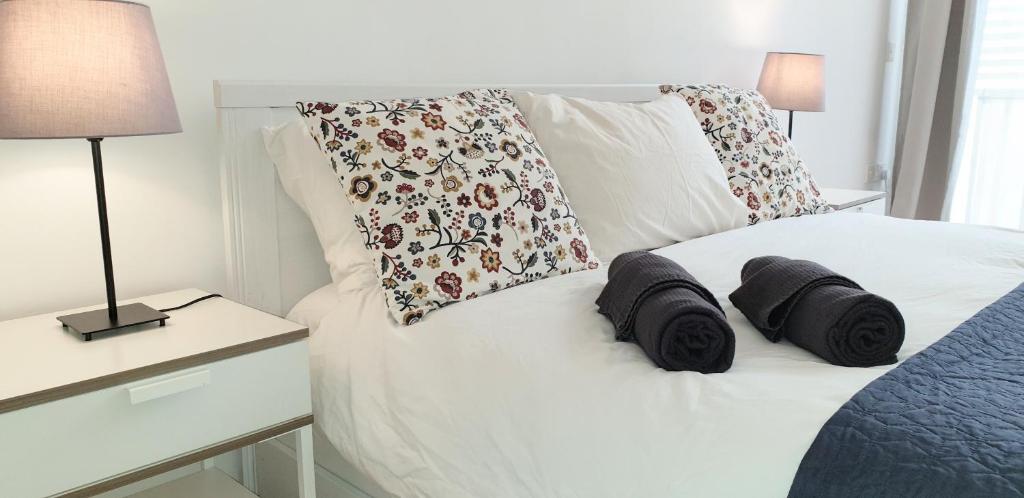 Un dormitorio con una cama blanca con almohadas. en R1102ERI by euroresort, en Marsalforn