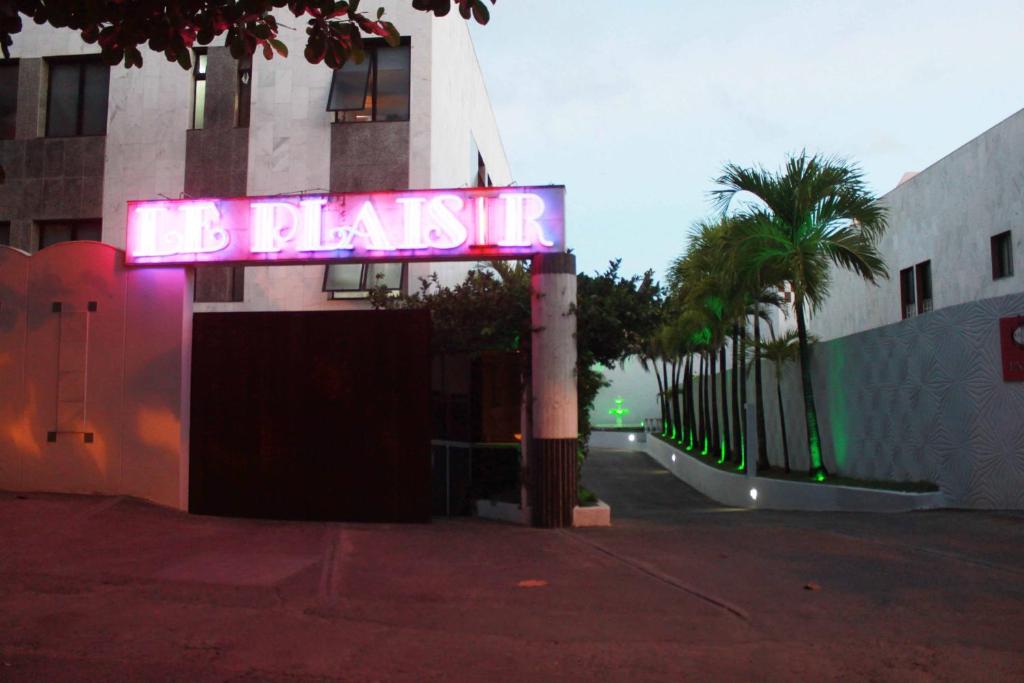a neon sign that says do platz in front of a building at Motel Le Plaisir in Salvador