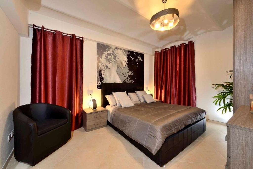 um quarto com uma cama com cortinas vermelhas e uma cadeira em Casa Calari 2 em Casa Calari