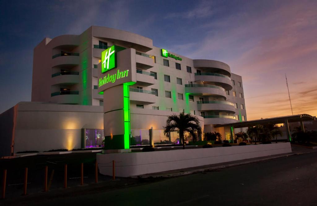 un bâtiment avec un panneau vert devant lui dans l'établissement Holiday Inn Campeche, an IHG Hotel, à Campeche