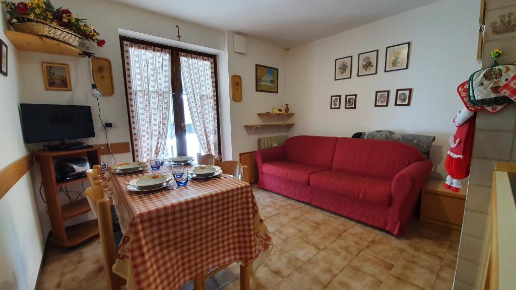 a living room with a red couch and a table at Appartamento a 200 Metri dalle Piste da Sci in Santa Caterina Valfurva
