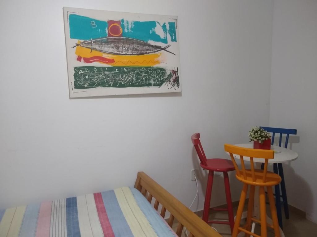 a bedroom with a bed and a table and chairs at Hostel casa amarela in Rio das Ostras