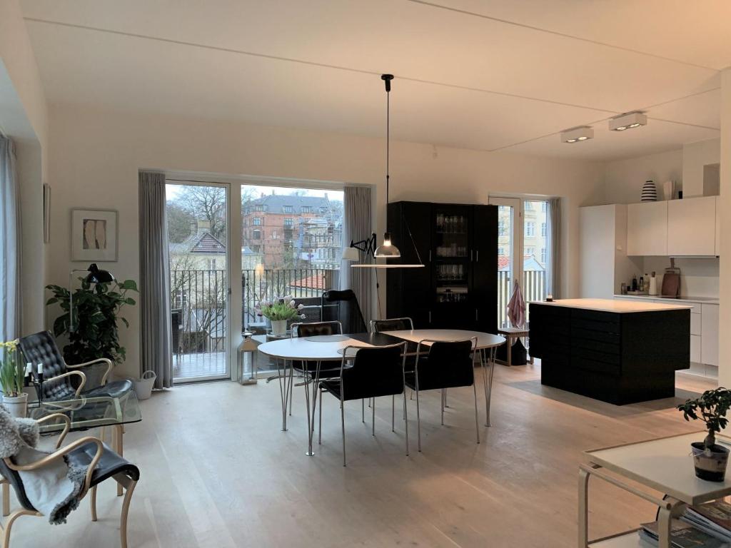ApartmentInCopenhagen Apartment 1440 في كوبنهاغن: مطبخ وغرفة معيشة مع طاولات وكراسي