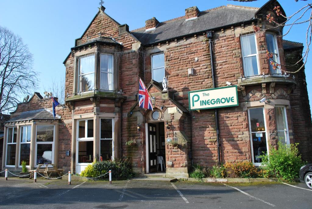 a brick building with a sign on the front of it at Pinegrove Hotel in Carlisle