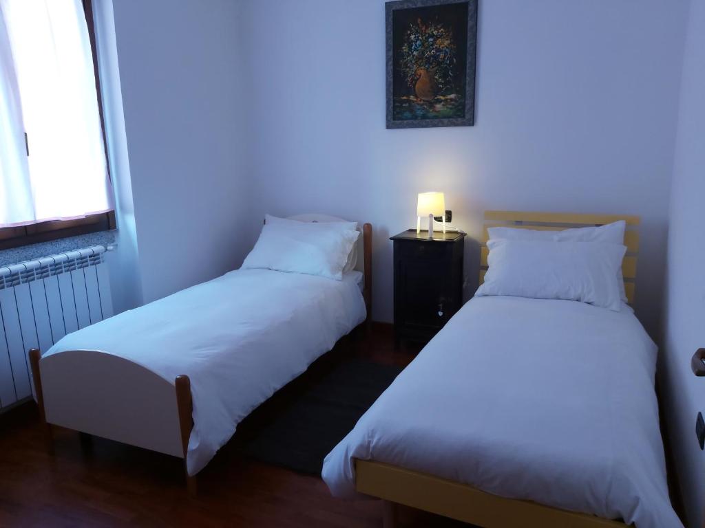 two beds in a room with a blue light at CASA LAGHETTO in Bovegno