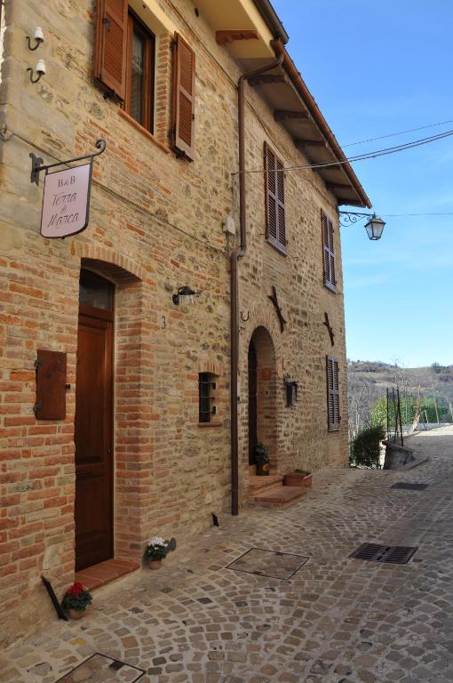 un edificio di mattoni con un cartello sul lato di B&B Terra di Marca a Montefortino