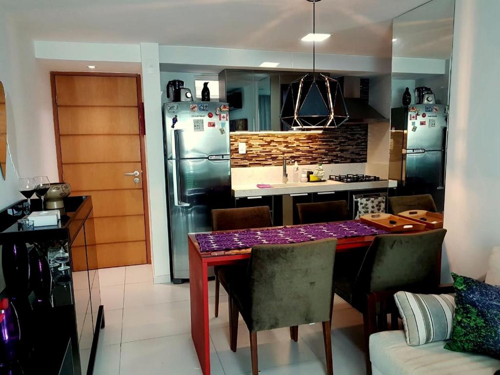 a kitchen with a table with chairs and a kitchen with a refrigerator at Israel Flat Tambau 209 PRIME in João Pessoa