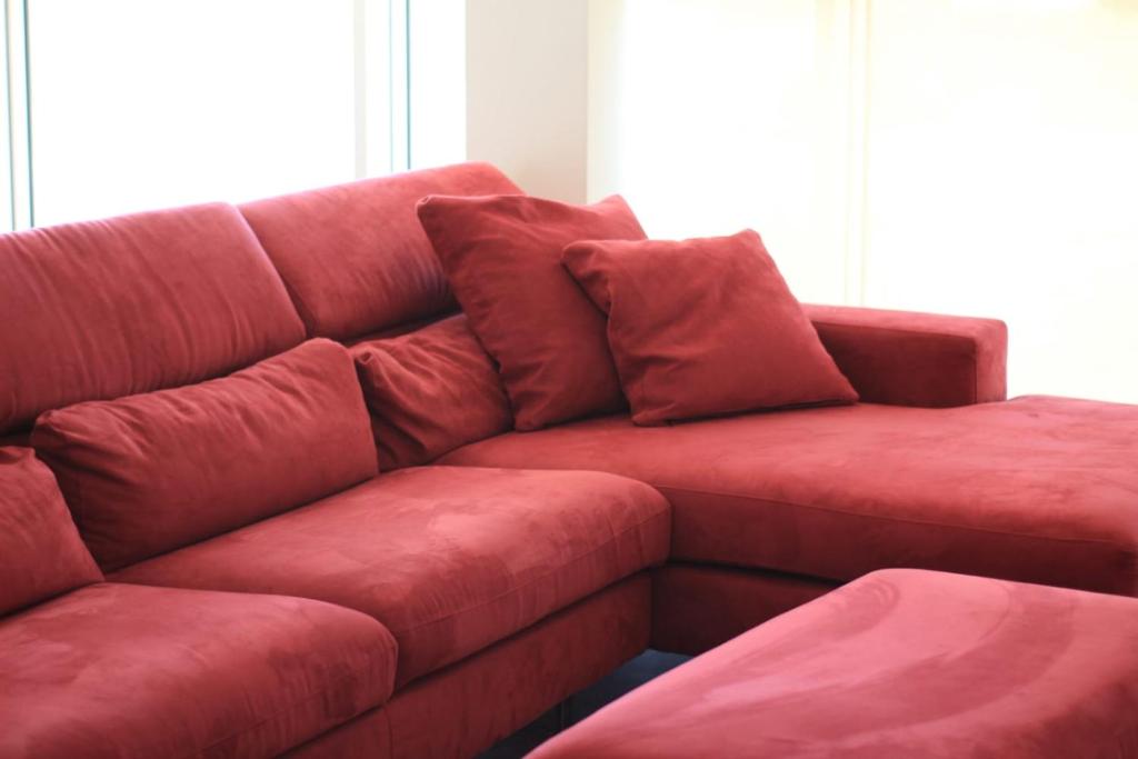 Un sofá rojo con dos almohadas. en Casa Plancia en Lecce