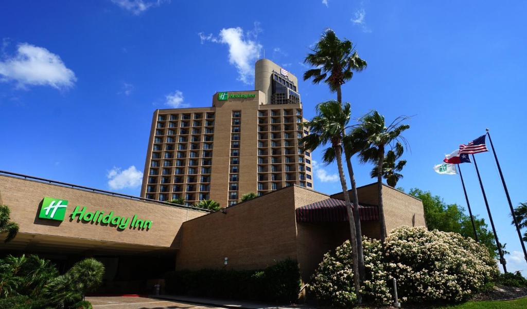 un hôtel hawaïen hilton avec des palmiers et un bâtiment dans l'établissement Holiday Inn Corpus Christi Downtown Marina, an IHG Hotel, à Corpus Christi