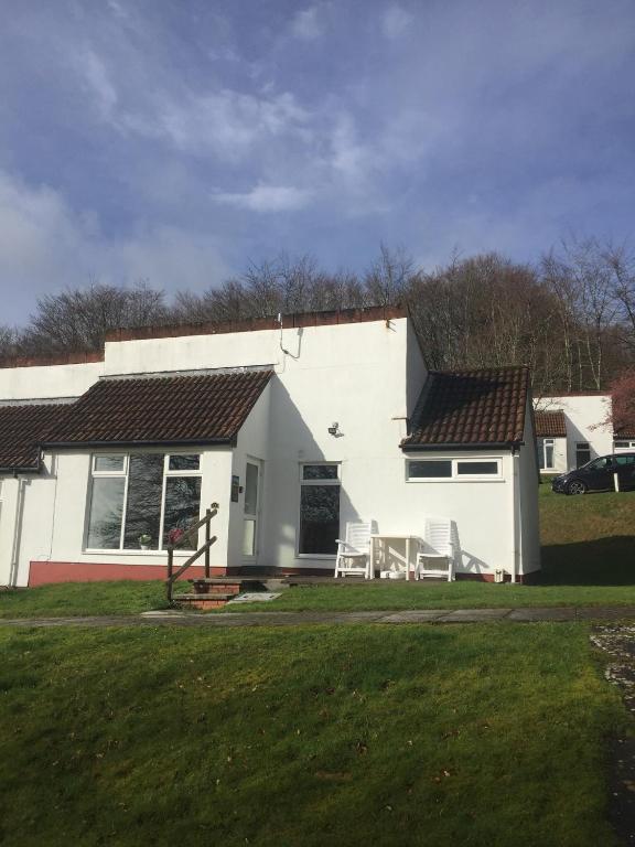 a white house with a lawn in front of it at Rock Cottage in Callington