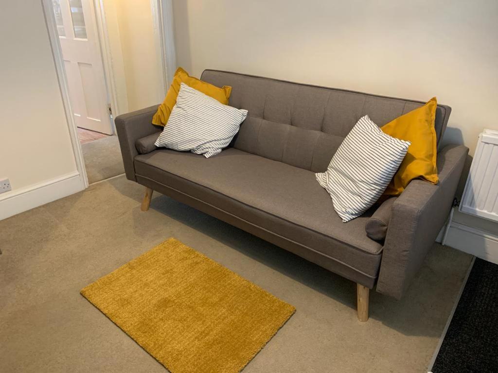 a gray couch with yellow pillows in a living room at The Salisbury Townhouse in Salisbury