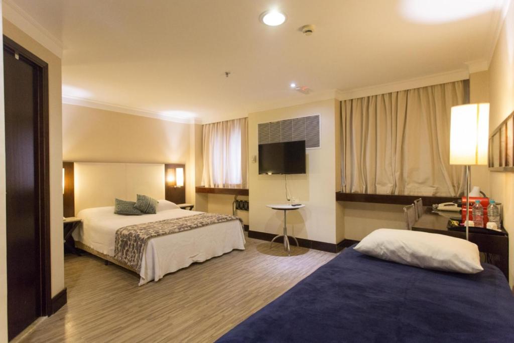 ein Hotelzimmer mit 2 Betten und einem Flachbild-TV in der Unterkunft (1505)Flat Prime Paulista (Apt. particular) in São Paulo