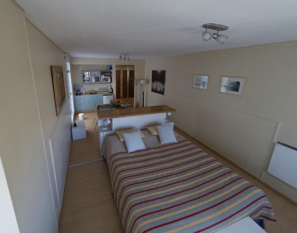Dormitorio pequeño con cama con manta a rayas en Concord Callao en Buenos Aires