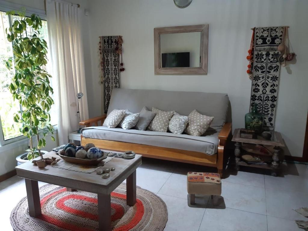 sala de estar con sofá y mesa en CHALET EN EL BOSQUE en Valeria del Mar