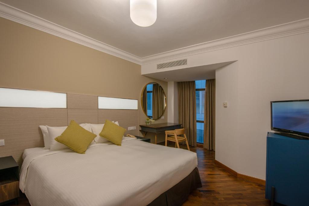 a hotel room with a bed and a television at YWCA Fort Canning in Singapore