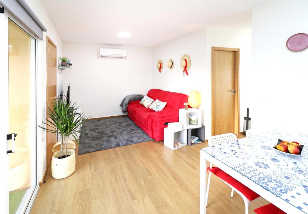 ein Wohnzimmer mit einem roten Sofa und einem Tisch in der Unterkunft Welcoming House in Medros with Terrace in Medros