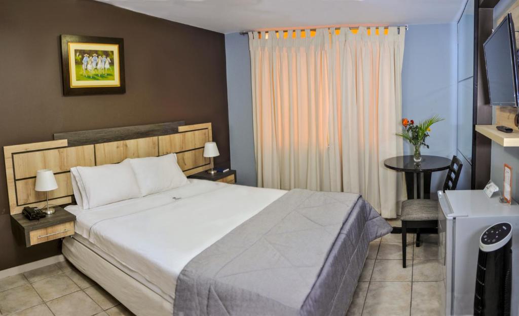 1 dormitorio con cama, mesa y ventana en Hotel Chimu, en Trujillo