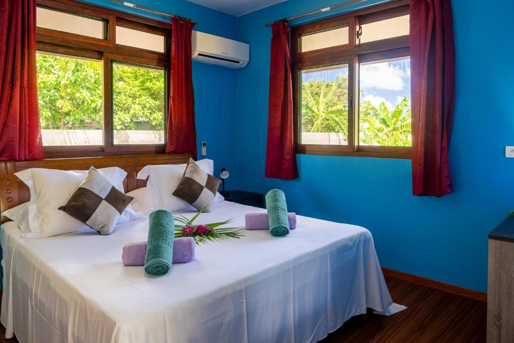 1 dormitorio con 2 camas, paredes y ventanas azules en Kovailani 1232 DTO-MT, en Bora Bora