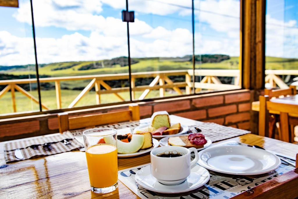 einen Tisch mit einem Teller Essen und einer Tasse Kaffee in der Unterkunft Pousada Morada da Serra in Cambará