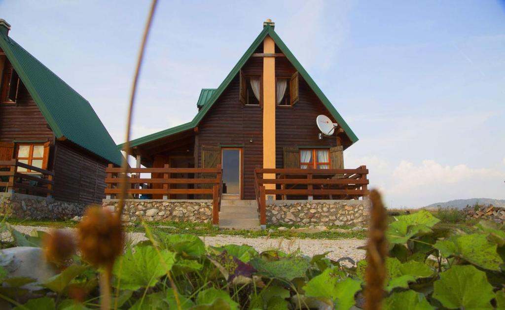 a small wooden house with a green roof at Mountain Vista Chalet in Žabljak