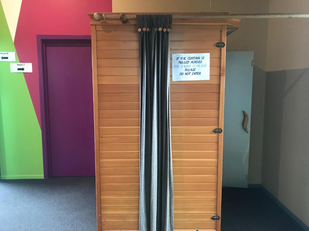 a wooden door with a sign on it in a room at YHA Nelson in Nelson