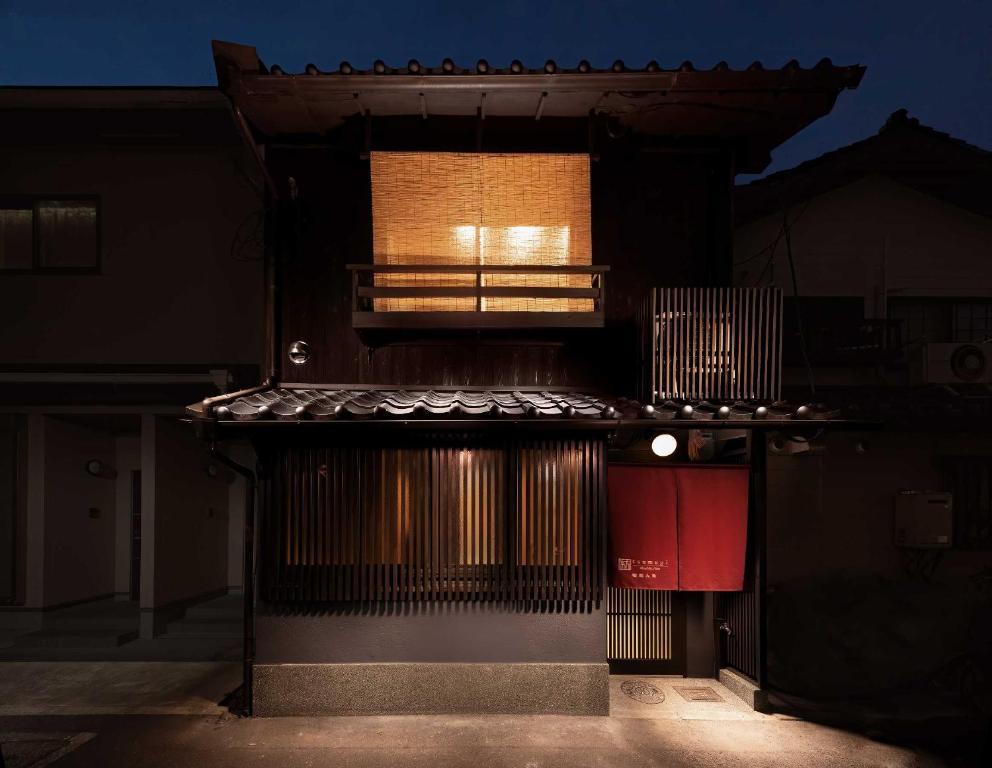 a building with a light on the side of it at Tsumugi Horikawarokkaku in Kyoto